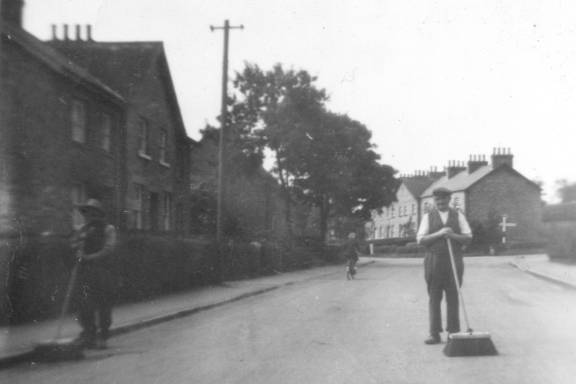 Two men with brooms in Main Street, Kirby Misperton