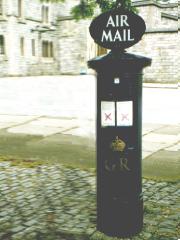 Blue pillar box with AIR MAIL sign.
