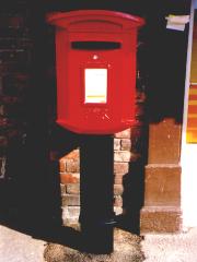 Small red letter box on a post.